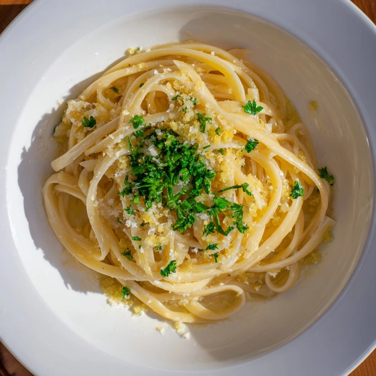 Bright, buttery lemon garlic pasta, perfectly coated, with a sprinkle of fresh parsley on top.