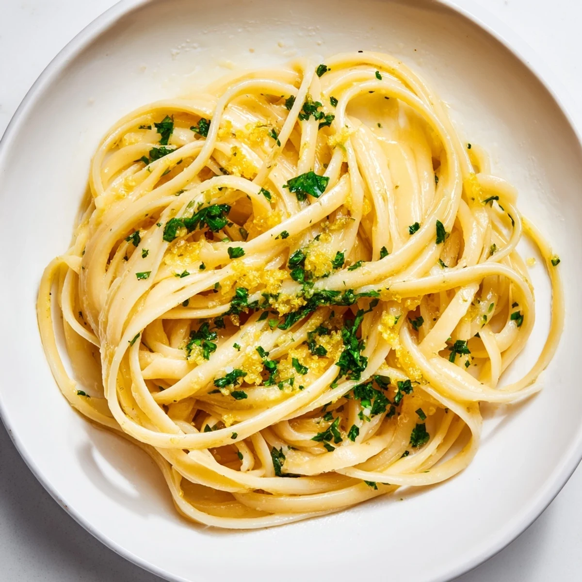 Golden strands of lemon garlic pasta tossed with Parmesan, a vibrant and flavor-packed vegetarian meal.