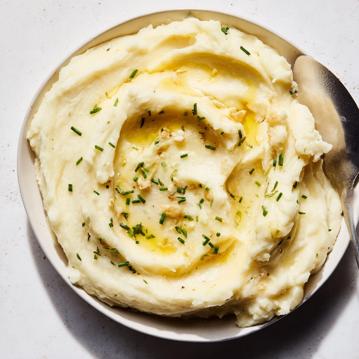 Fluffy garlic mashed potatoes, served in a bowl, with a creamy texture and savory aroma.