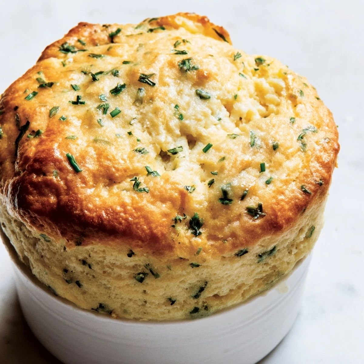 Fluffy Savory Cheese and Herb Soufflé, golden brown and airy, a classic French dish.