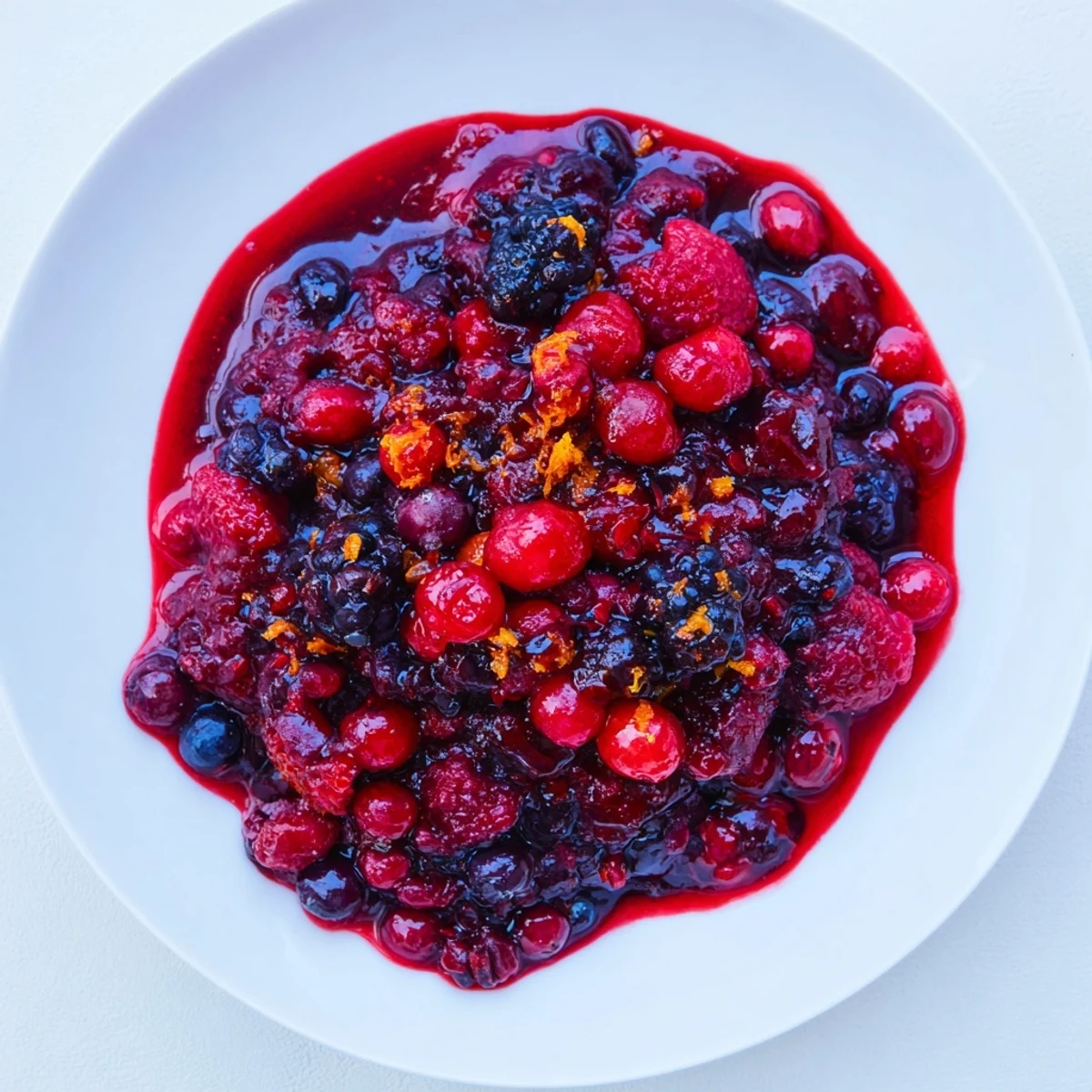 Vibrant red Cranberry Fresh Berry Compote glistening, perfect for topping creamy yogurt parfaits.