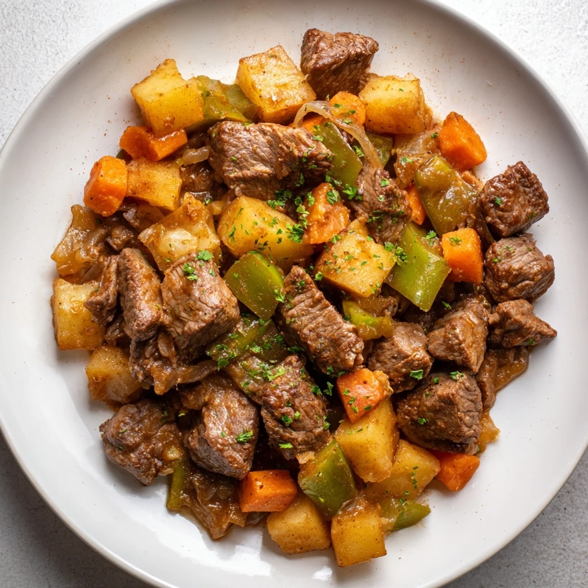 Close-up of steaming hot beef hash, showcasing juicy beef cubes and soft potatoes, ready to eat.