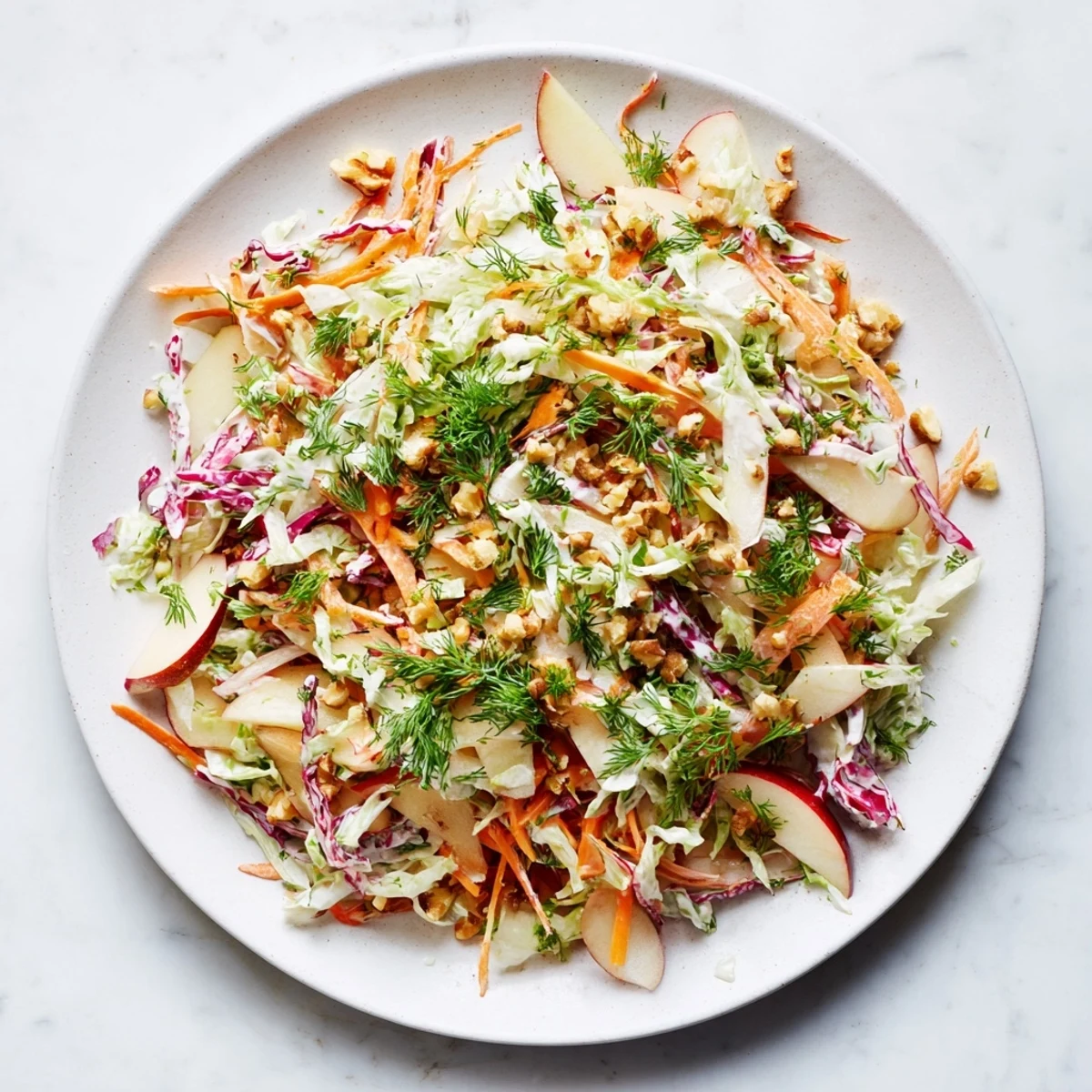 A close-up of a refreshing winter coleslaw with apple, loaded with fresh vegetables and apple slices.