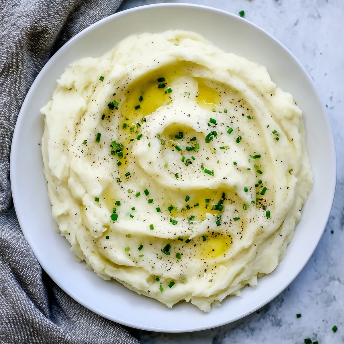 A close-up shot of perfectly whipped creamy mashed potatoes, seasoned with pepper, ready to enjoy.