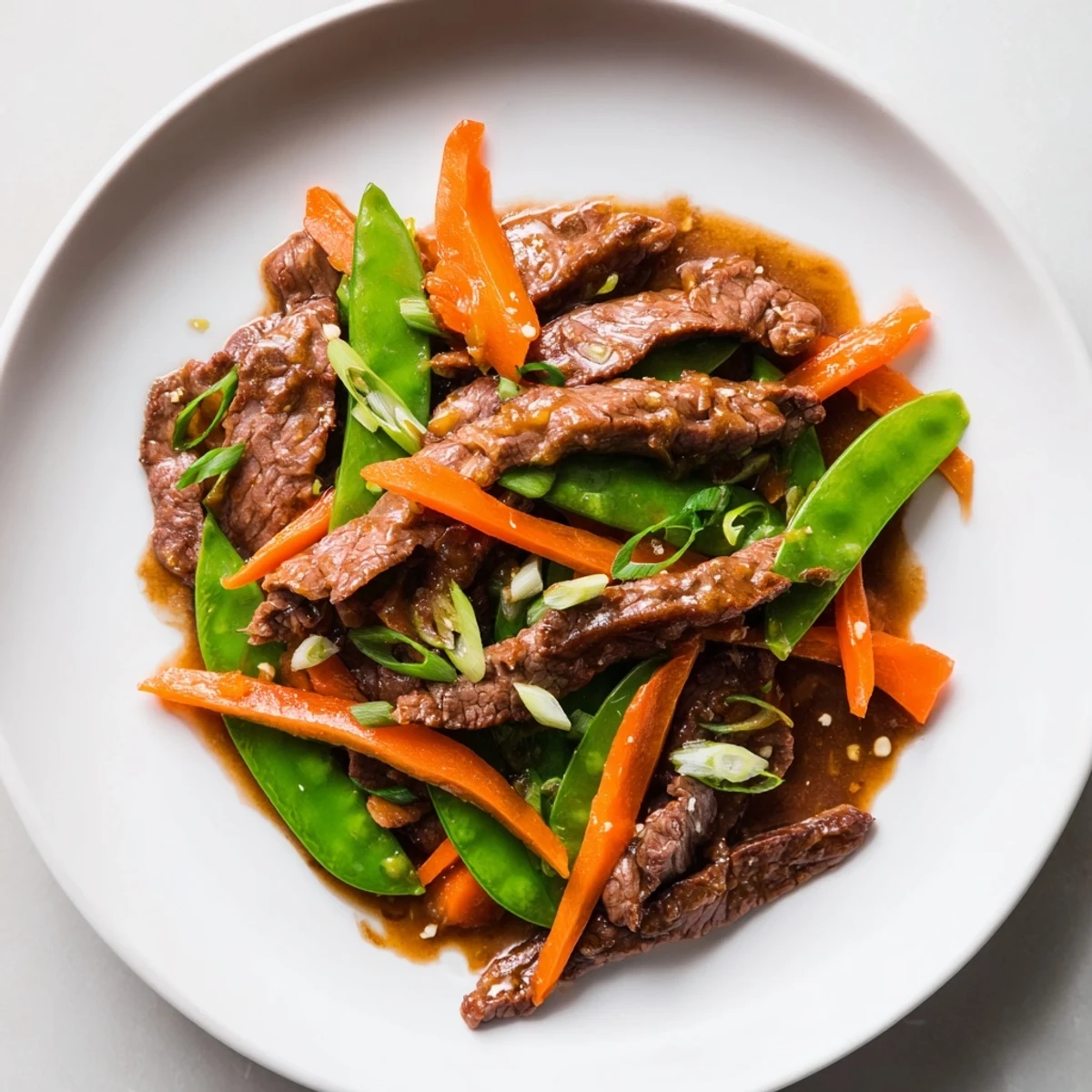 Savory Beef Stir Fry: a colorful stir-fry with glistening beef, snow peas, and carrots, ready to eat.