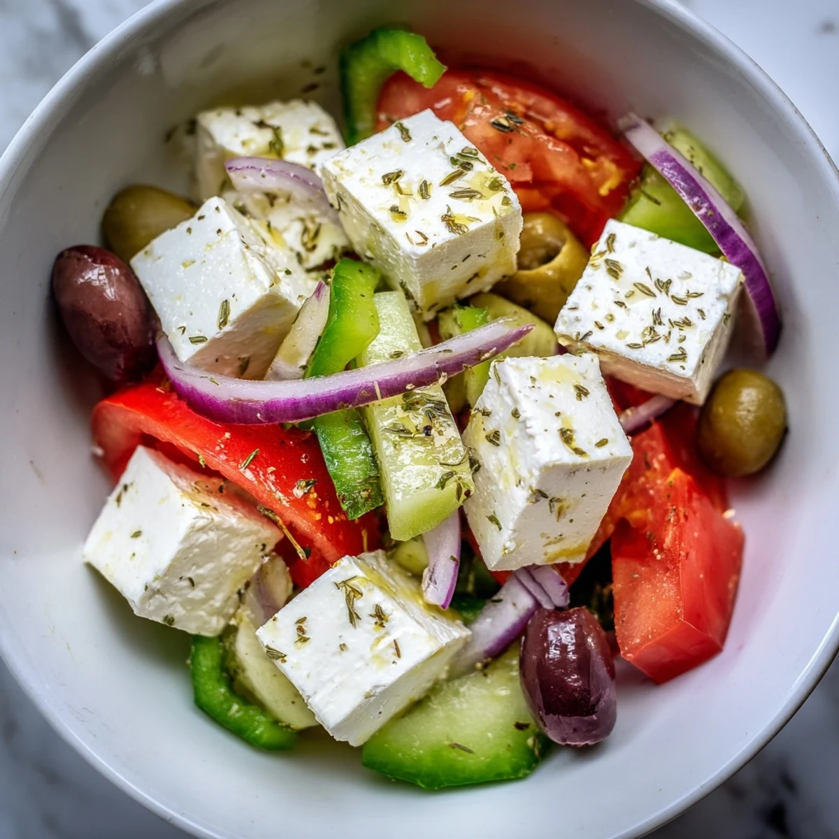 A Mediterranean-inspired Greek Salad with Kalamata Olives and Feta Cheese, featuring briny olives and creamy feta tossed with crisp vegetables for a refreshing bite.