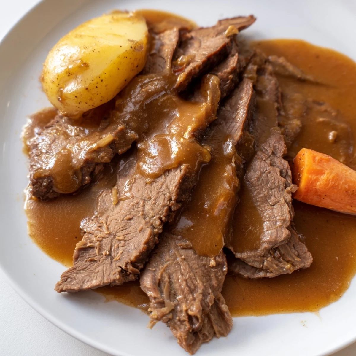 Close-up of Slow Cooker Pot Roast with Gravy, showing juicy beef chunks and glazed root vegetables.