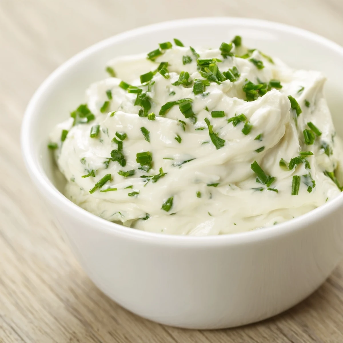 A close-up of rich and smooth Creamy Snack Dip in a serving bowl, surrounded by colorful pita chips and crunchy pretzels. 