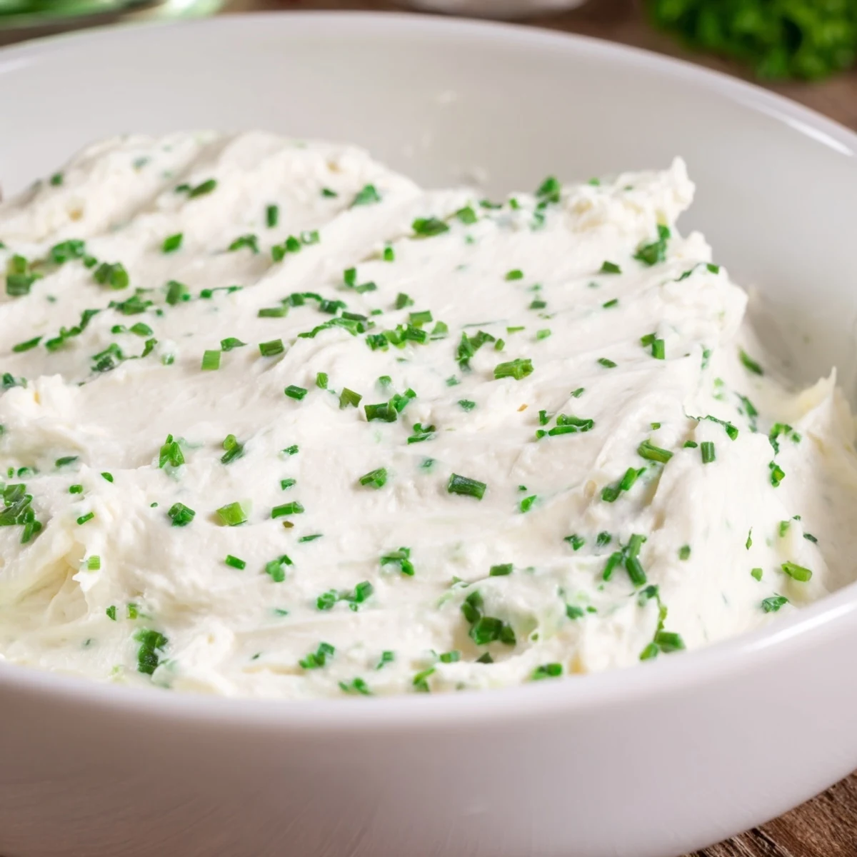 Spooned from a ceramic bowl, the savory Creamy Snack Dip is paired with fresh celery and carrot sticks ready to eat.