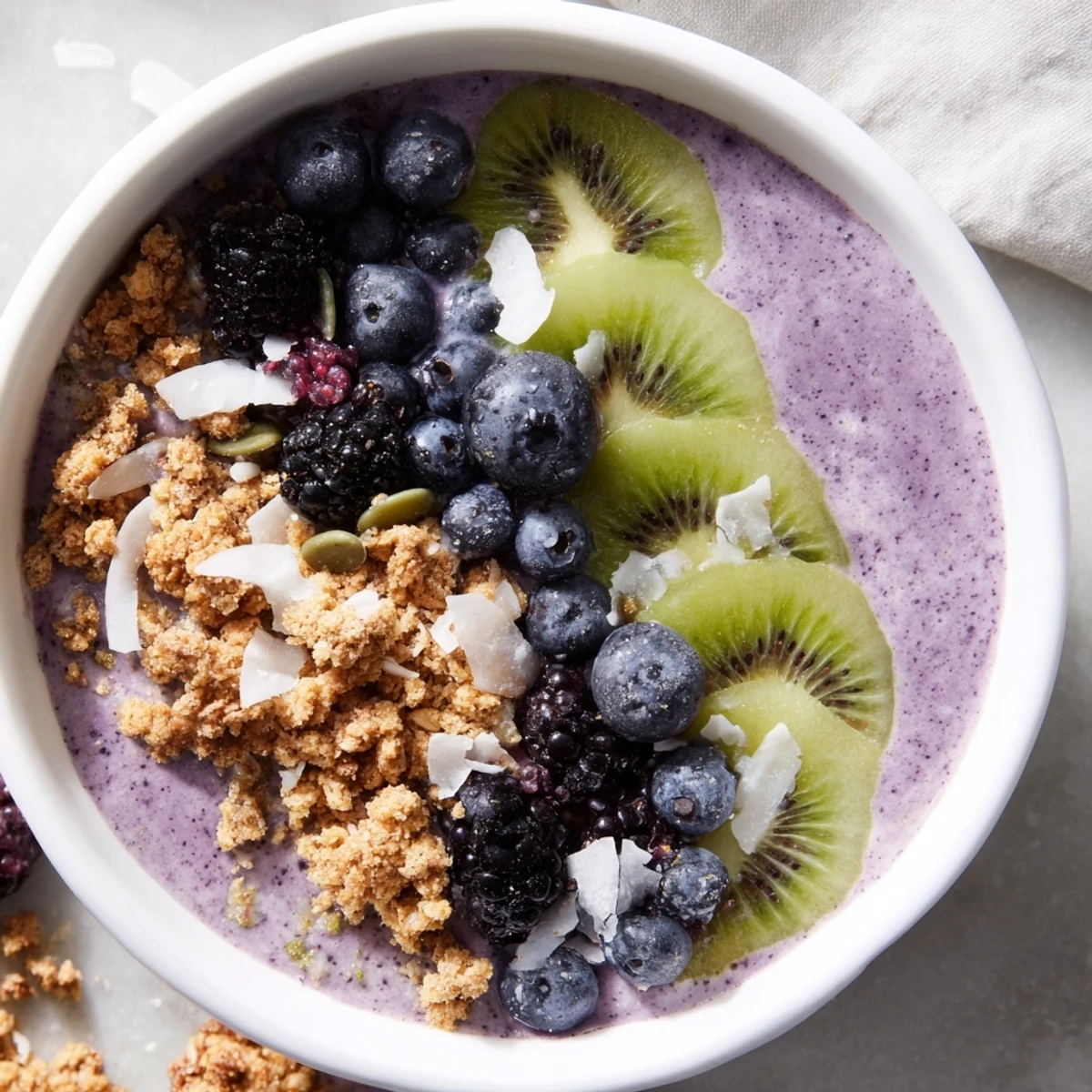 Colorful Winter Berry Smoothie Bowl garnished with granola, coconut flakes, and fresh berries.
