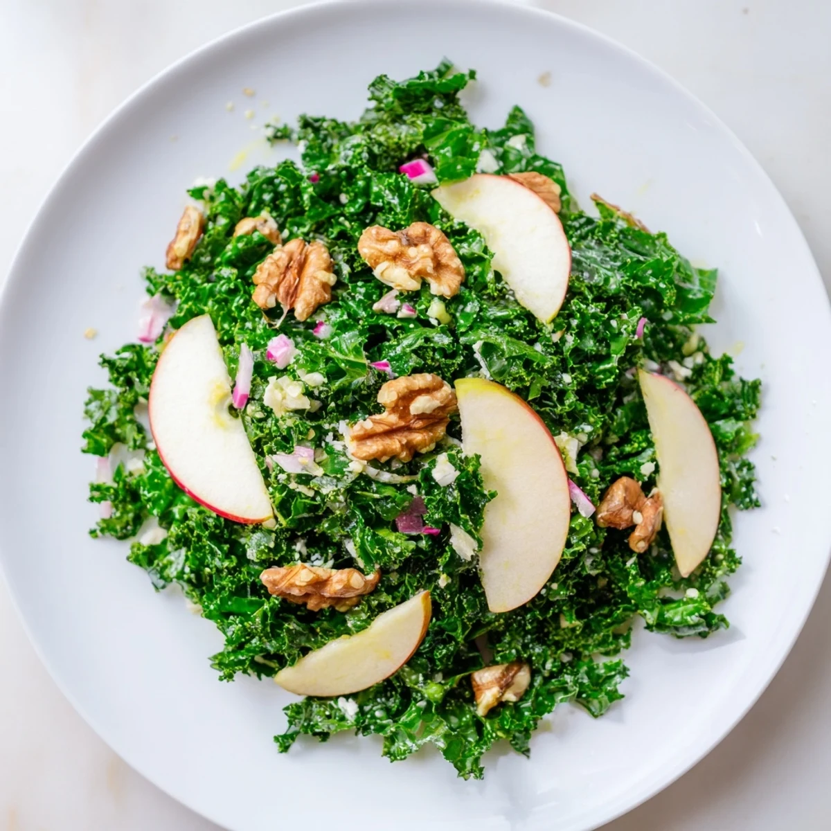 Green Kale and Apple Salad with Walnuts served in a white ceramic bowl, ready for a light lunch or side dish.