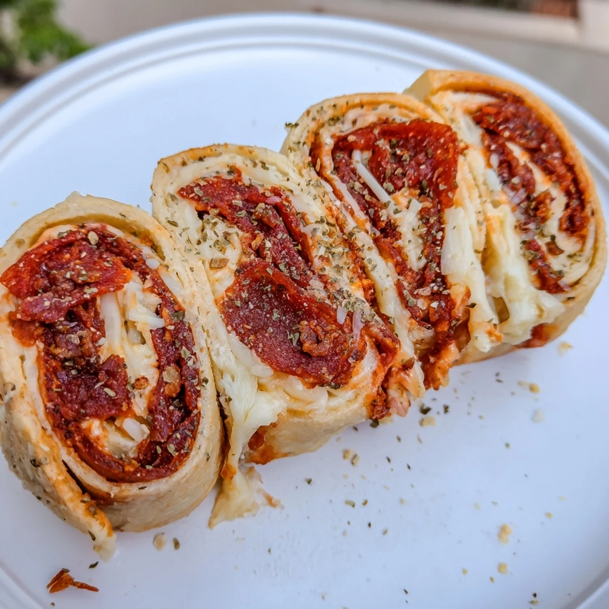 Warm Game Day Pizza Rolls with Beef Pepperoni served with a side of pizza sauce for dipping on a game day spread.