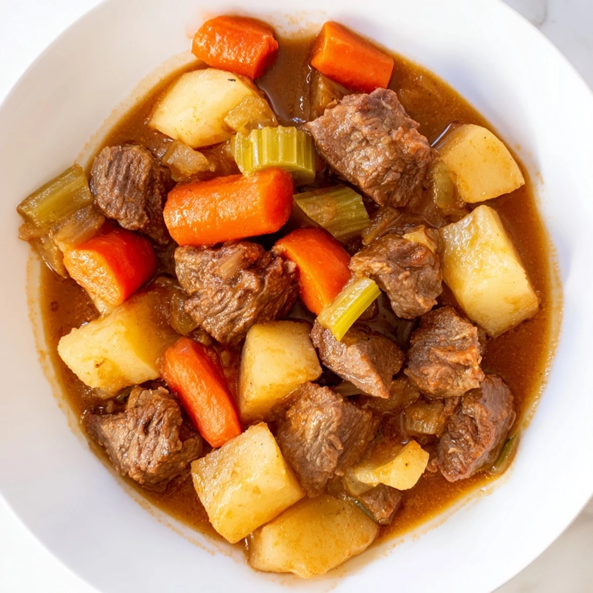 Golden Savory Beef Stew with Root Vegetables simmers with tender carrots, potatoes, and parsnips in rich broth.