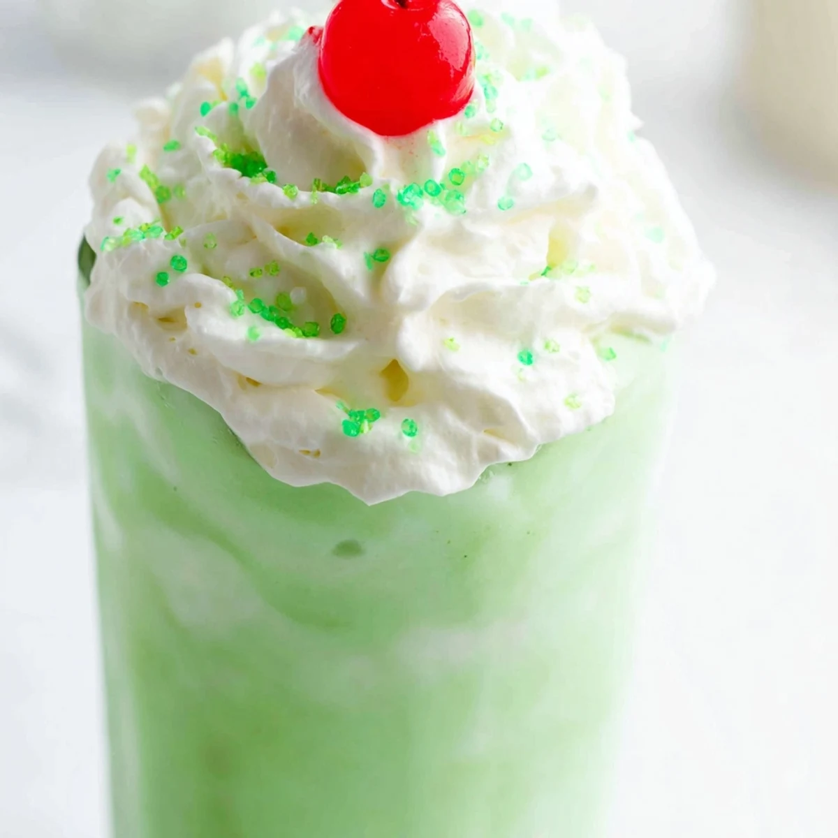 Homemade Copycat Shamrock Shake with minty green ice cream, swirled with whipped cream and a cherry on top for St. Patrick's Day.