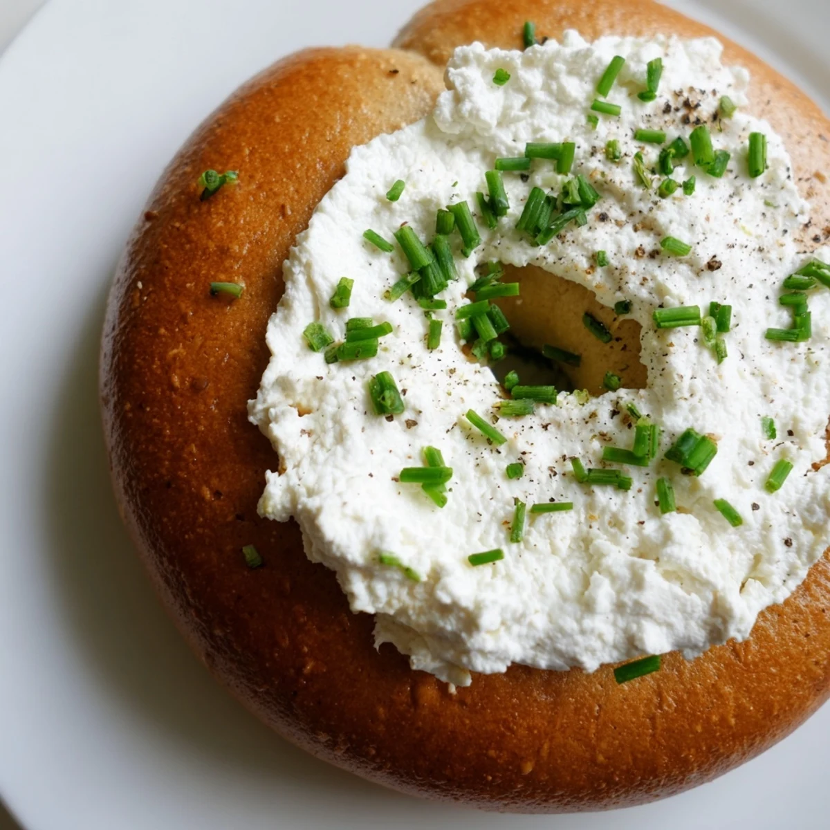 Warm Protein Bagels with Cottage Cheese showcase a chewy texture, served alongside a small bowl of extra cottage cheese and cracked black pepper.