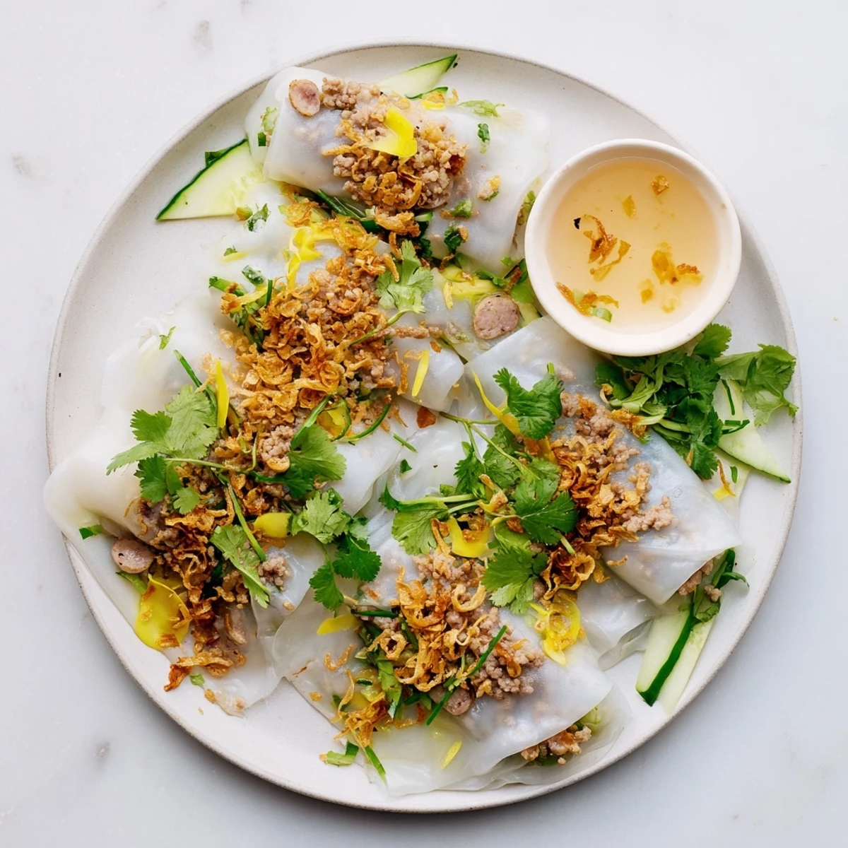 Thin, delicate Banh Cuon rice rolls filled with savory pork and wood ear mushrooms, served with fresh bean sprouts and herbs.