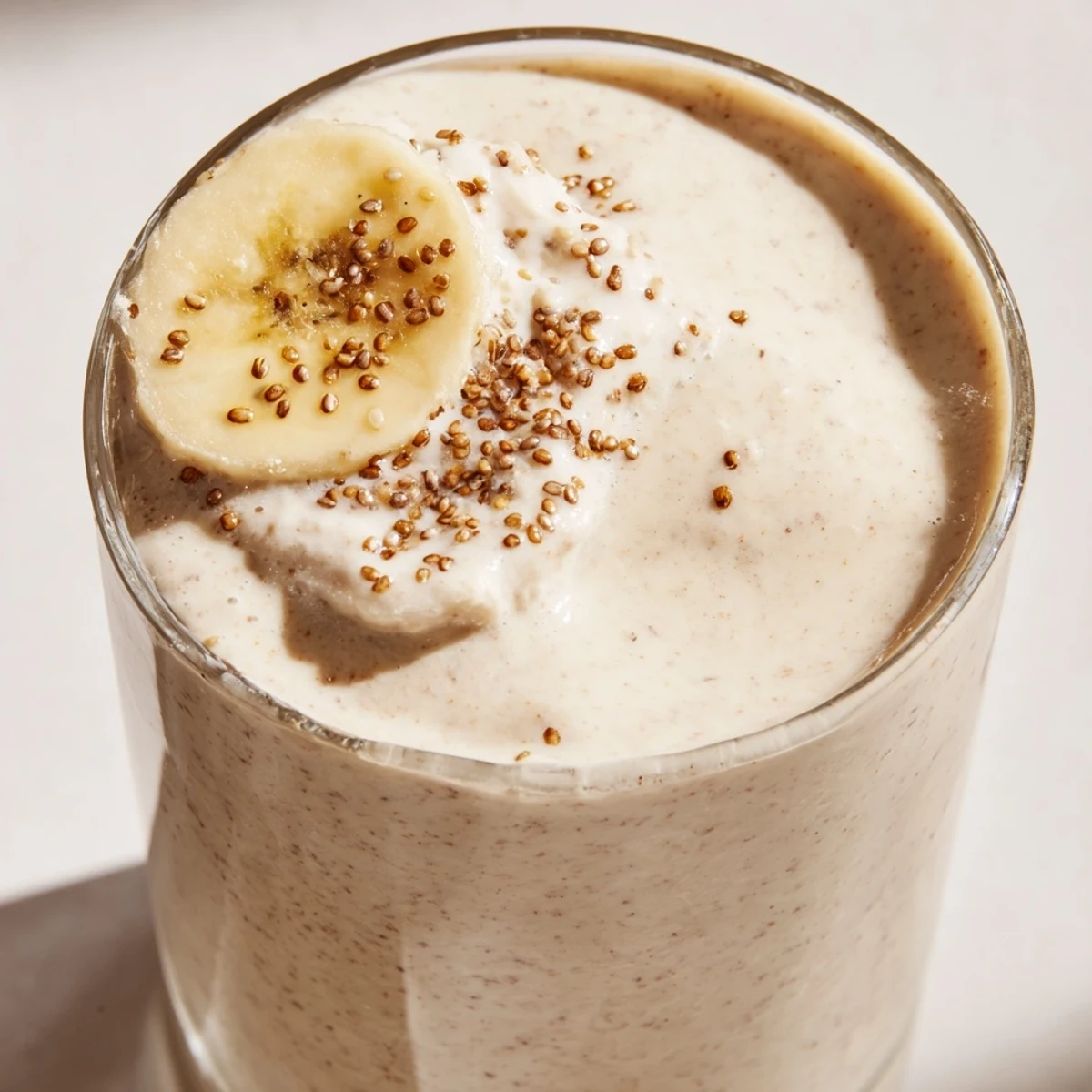 Protein-rich Greek yogurt banana smoothie in a tall glass with cinnamon sprinkled on top