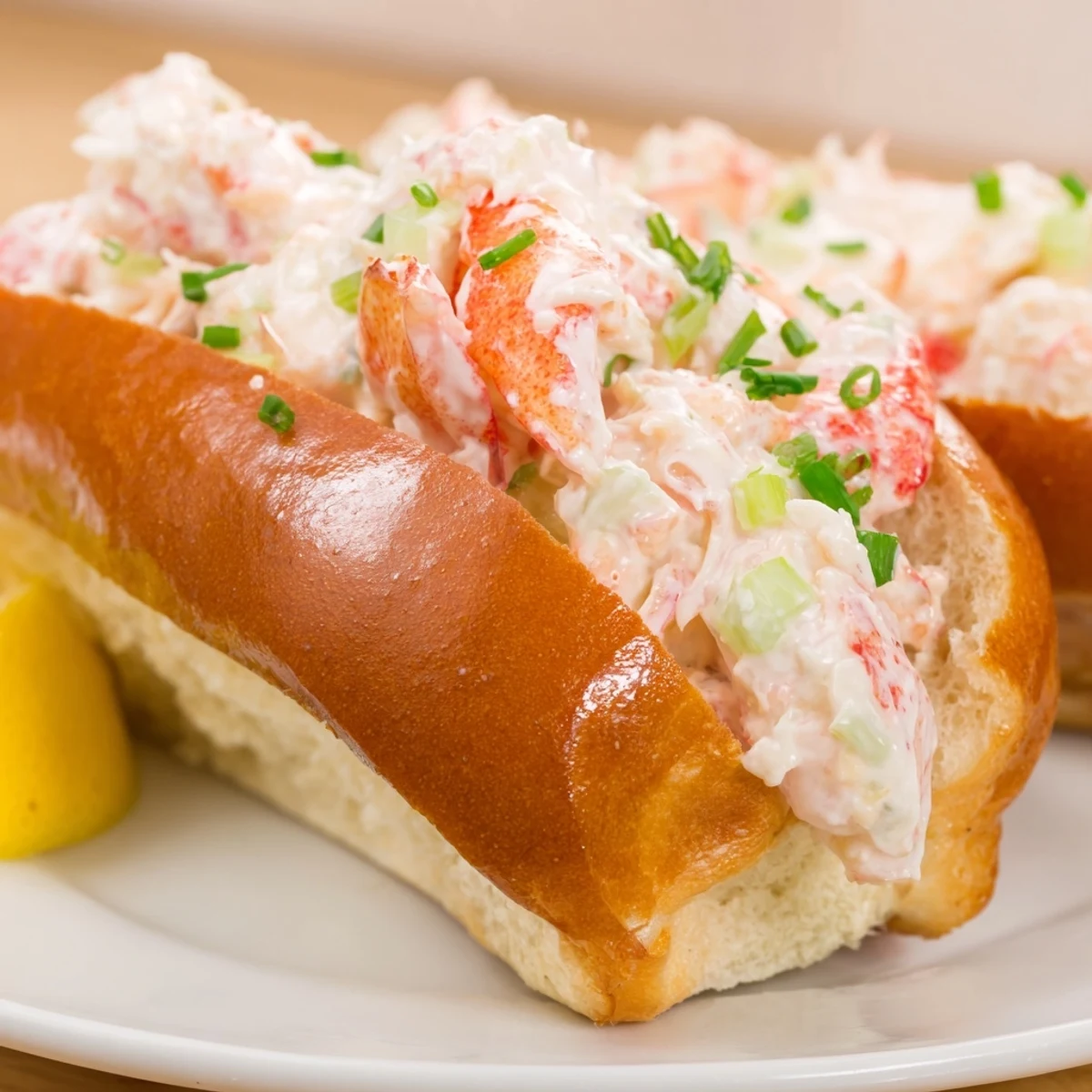 Golden toasted garlic butter lobster rolls stuffed with creamy herbed lobster filling on a plate