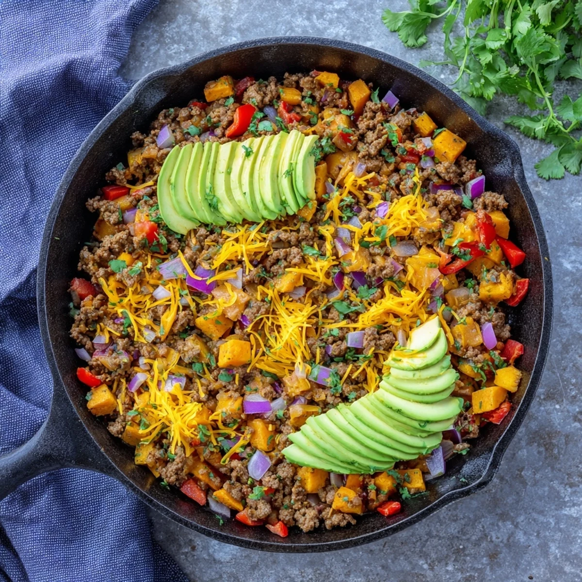 Hearty Southwest ground beef and sweet potato skillet seasoned with spices in a cast iron pan