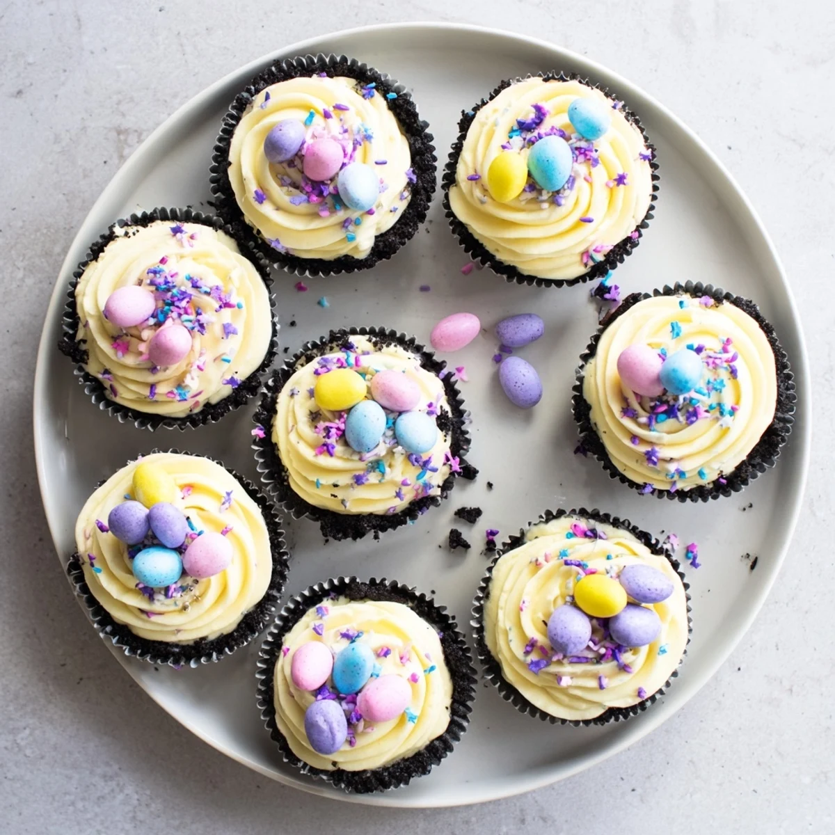 Mini Easter Cadbury Cheesecakes garnished with chopped candy eggs and fluffy whipped cream topping