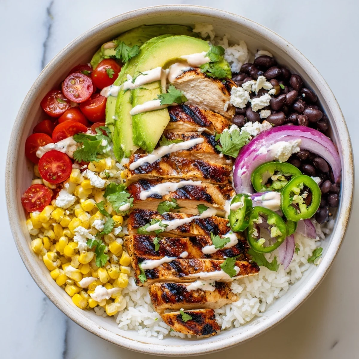Flavorful ultimate Baja style chicken bowl featuring fresh vegetables, zesty lime rice, and creamy dressing