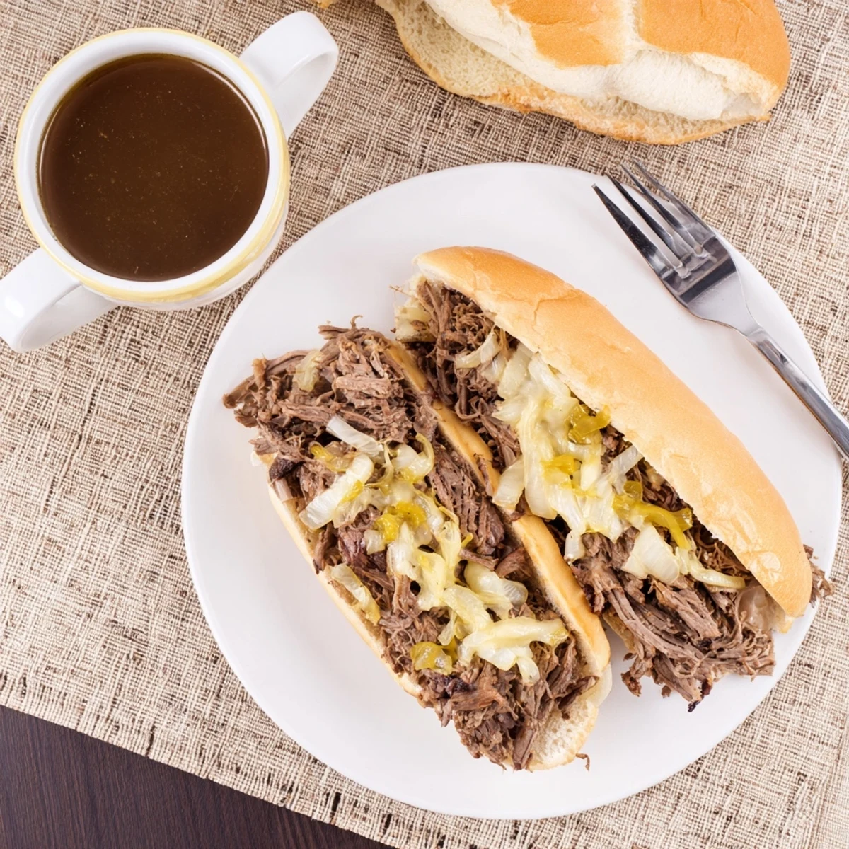 Shredded chuck roast slow-cooked for hours in savory broth for these Crockpot French Dip Sandwiches with dipping juice