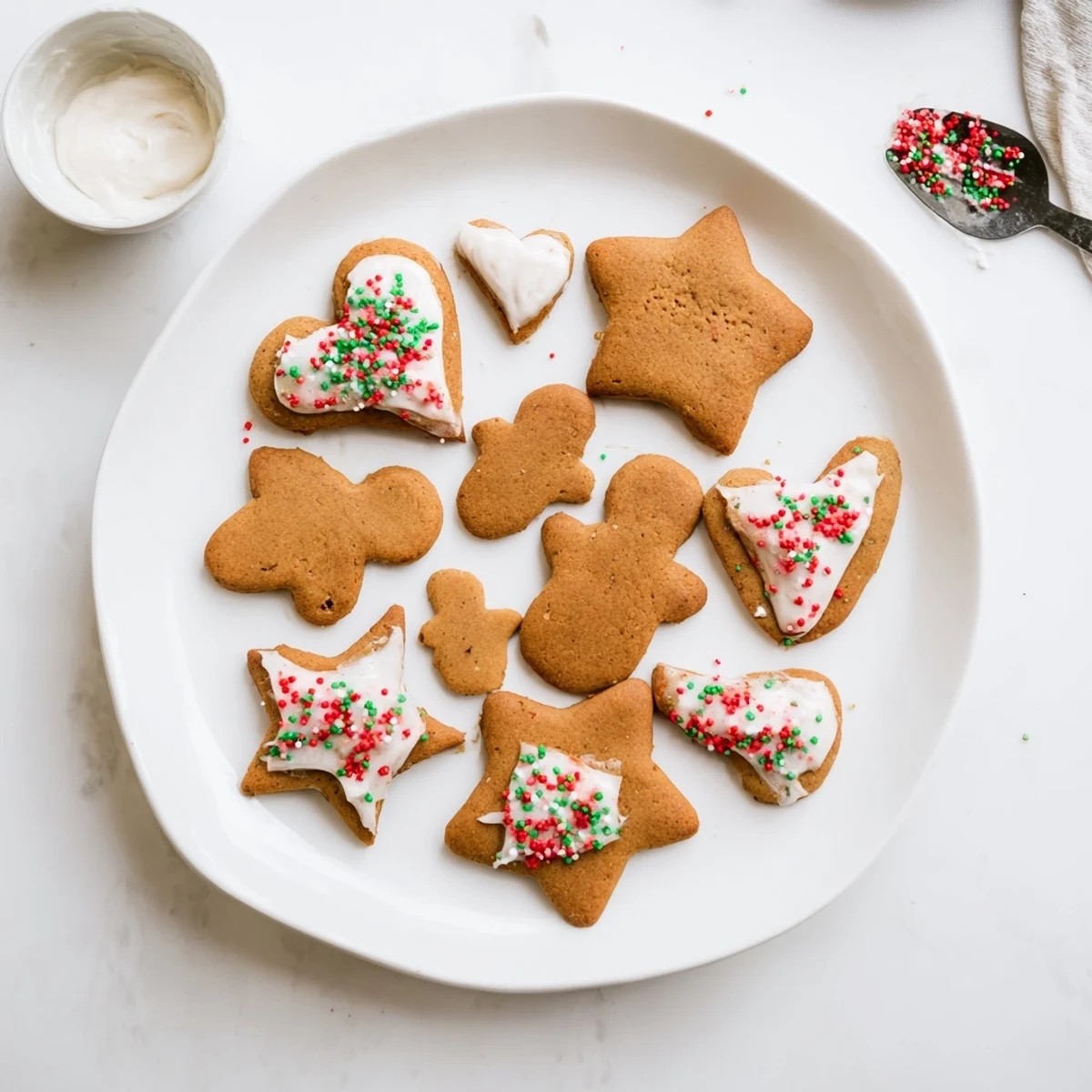 Golden brown gingerbread men cookies with piped icing faces and buttons displayed on a festive serving platter