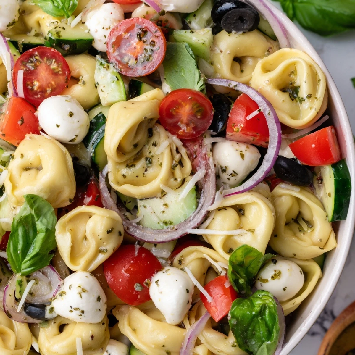 Cheese tortellini tossed with crisp vegetables and fresh basil in a vibrant summer salad