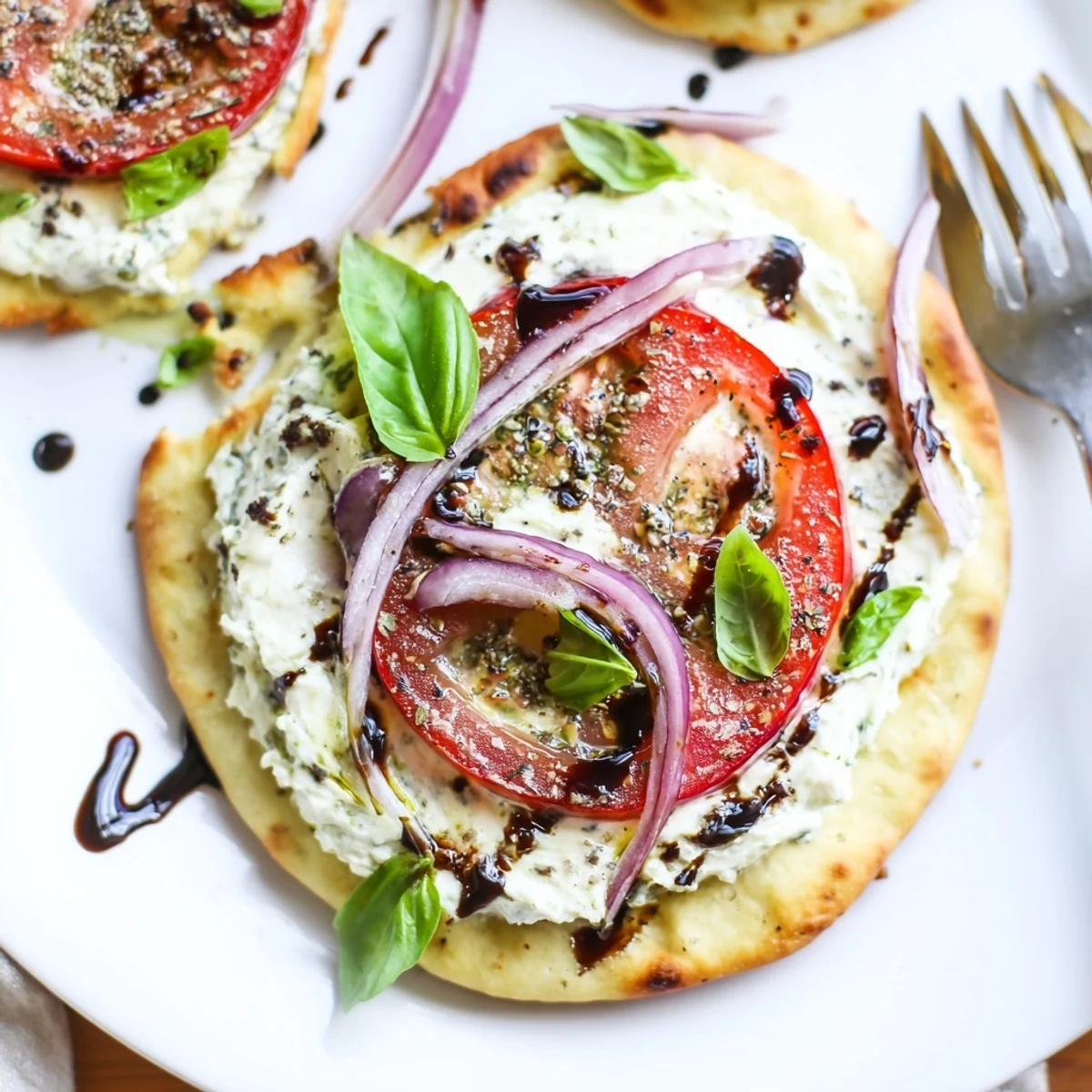 Oven golden Caprese Pita Pizza With Whipped Garlic Feta, melted mozzarella and juicy tomatoes