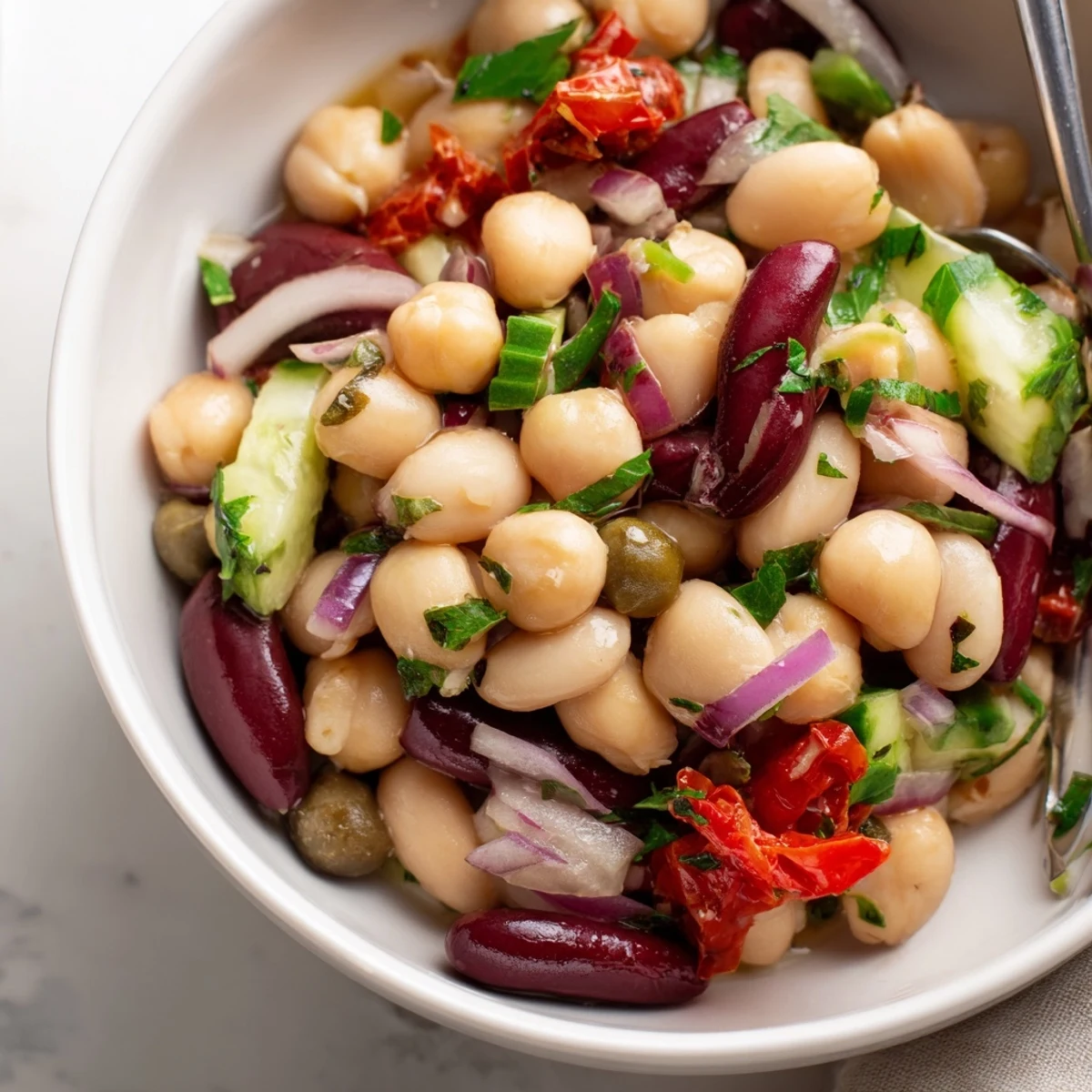 Dense Bean Salad With Sun Dried Tomatoes tossed with olive oil, fragrant parsley