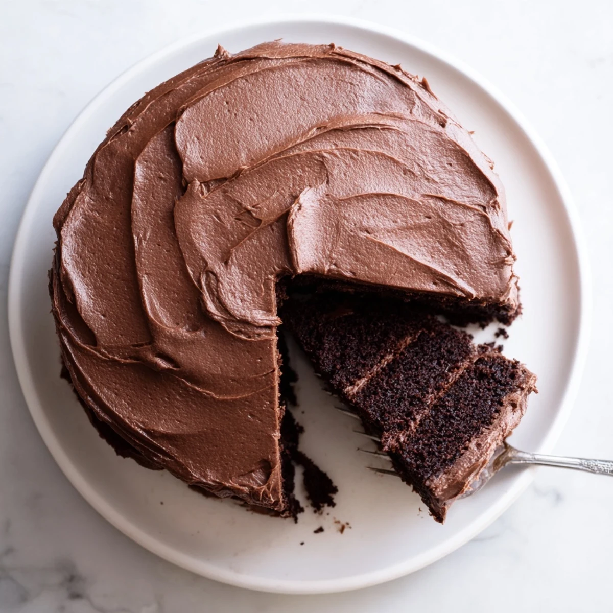 Decadent Matildas chocolate cake with rich cocoa frosting, sliced on a white plate