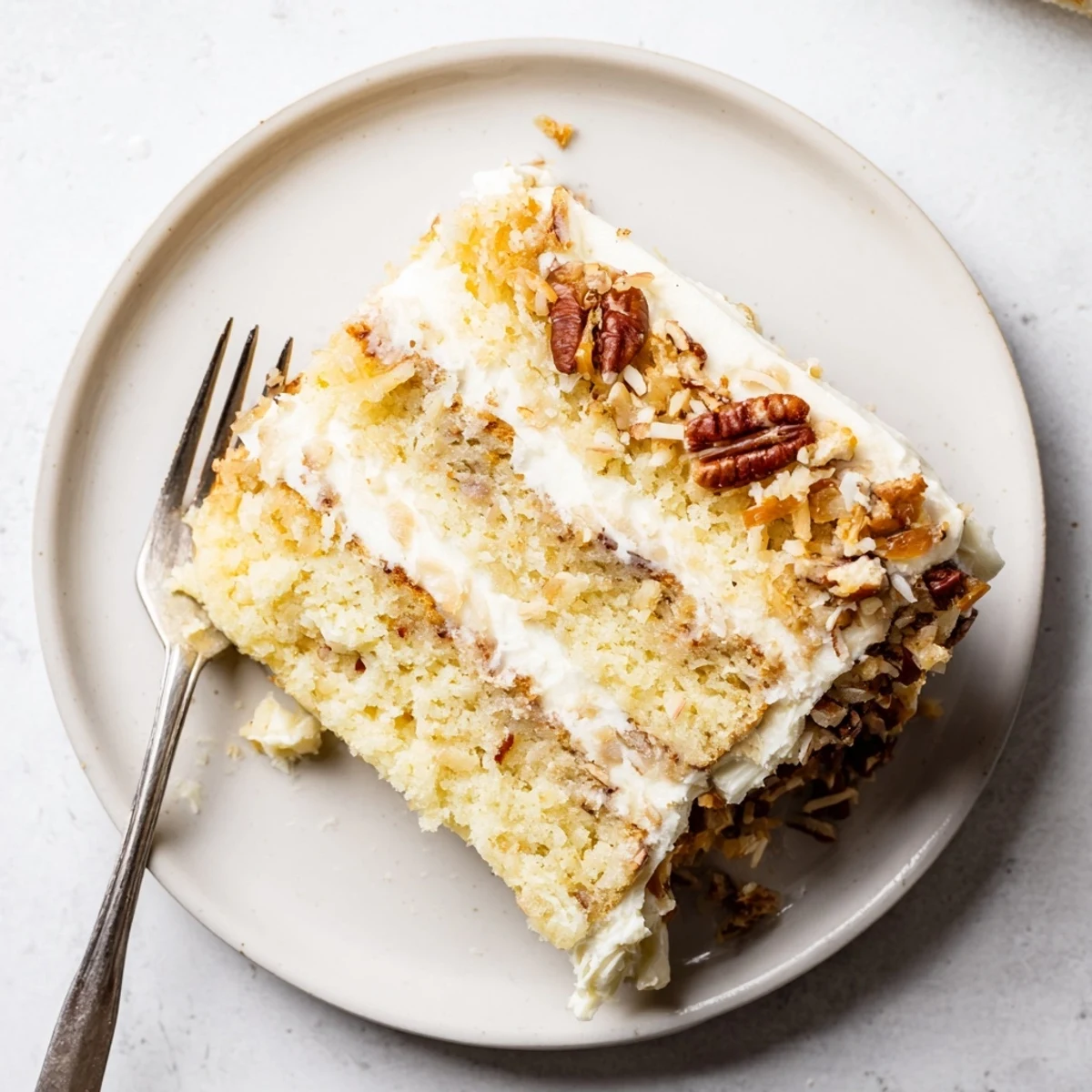 Rich and moist Quick Italian Cream Cake topped with creamy white frosting and sprinkled with toasted coconut and pecans