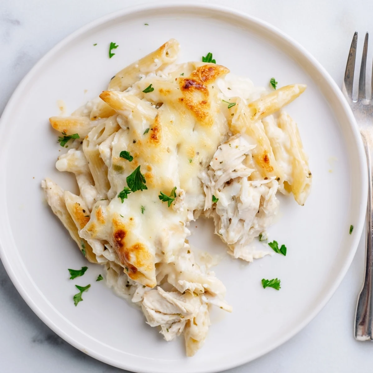Family-style Creamy Chicken Alfredo Bake With Mozzarella Crust, parsley garnish, oozing cheese