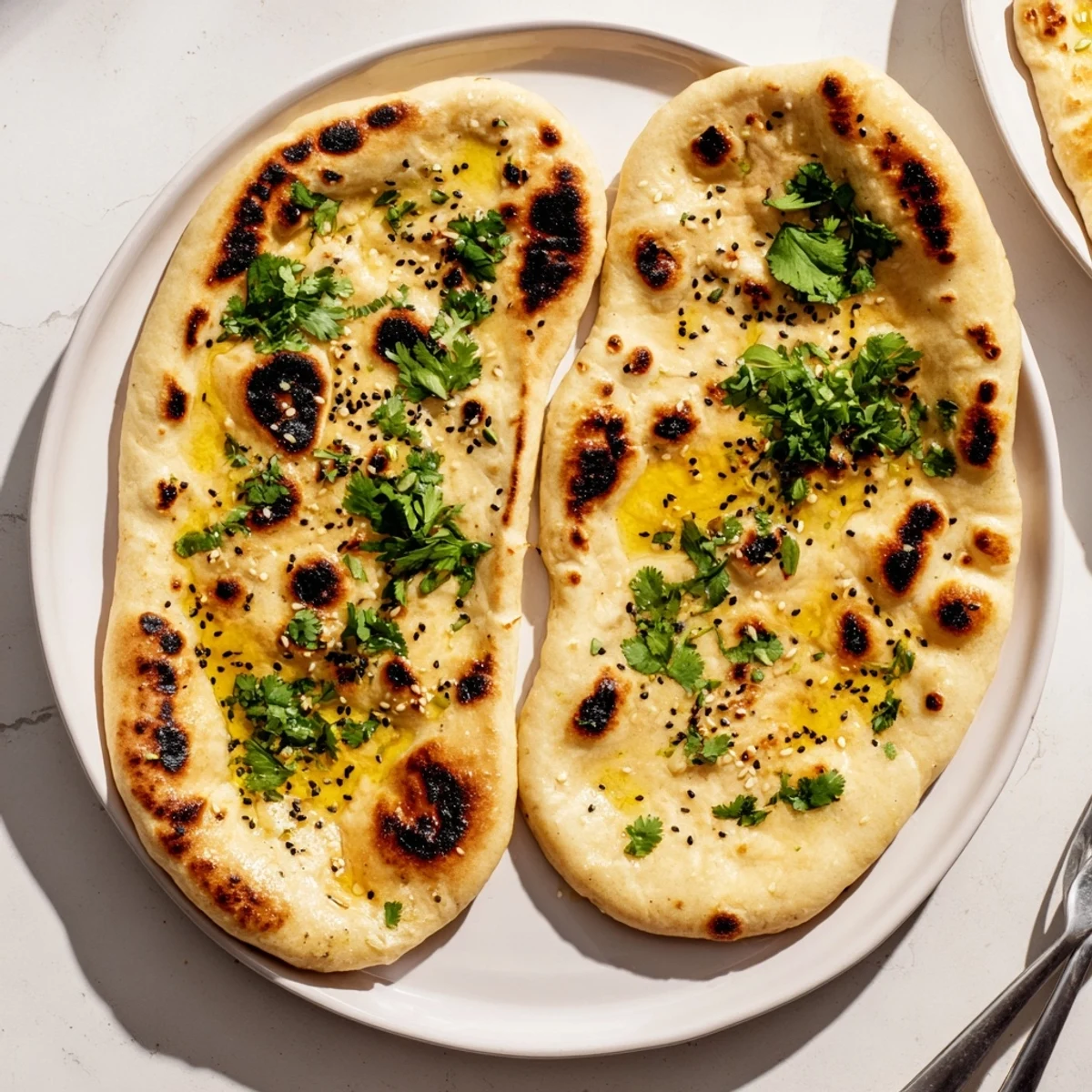 Golden brown sourdough discard soft naan brushed with melted butter and fresh cilantro