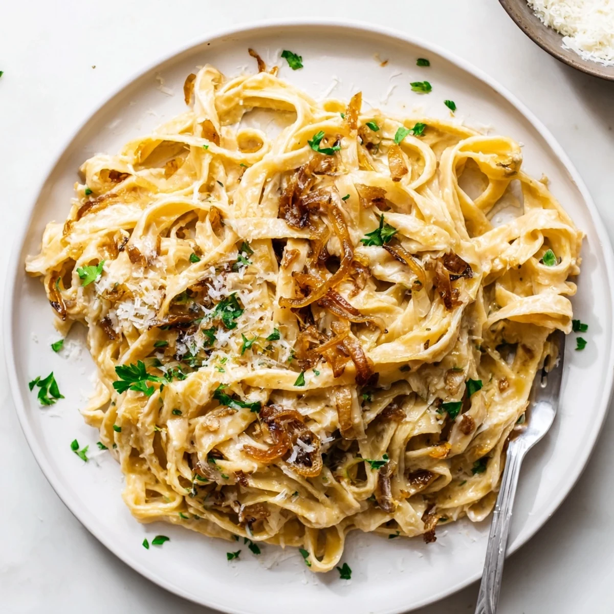 Golden brown caramelized onion cream pasta coated in silky parmesan sauce garnished with fresh parsley