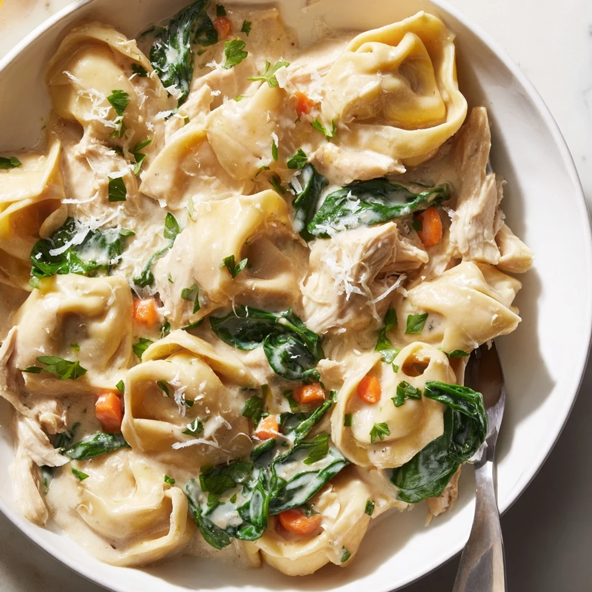 Slow cooker chicken tortellini with spinach and golden broth served steaming hot
